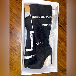 Black knee high stiletto heel boots with snake print design.
